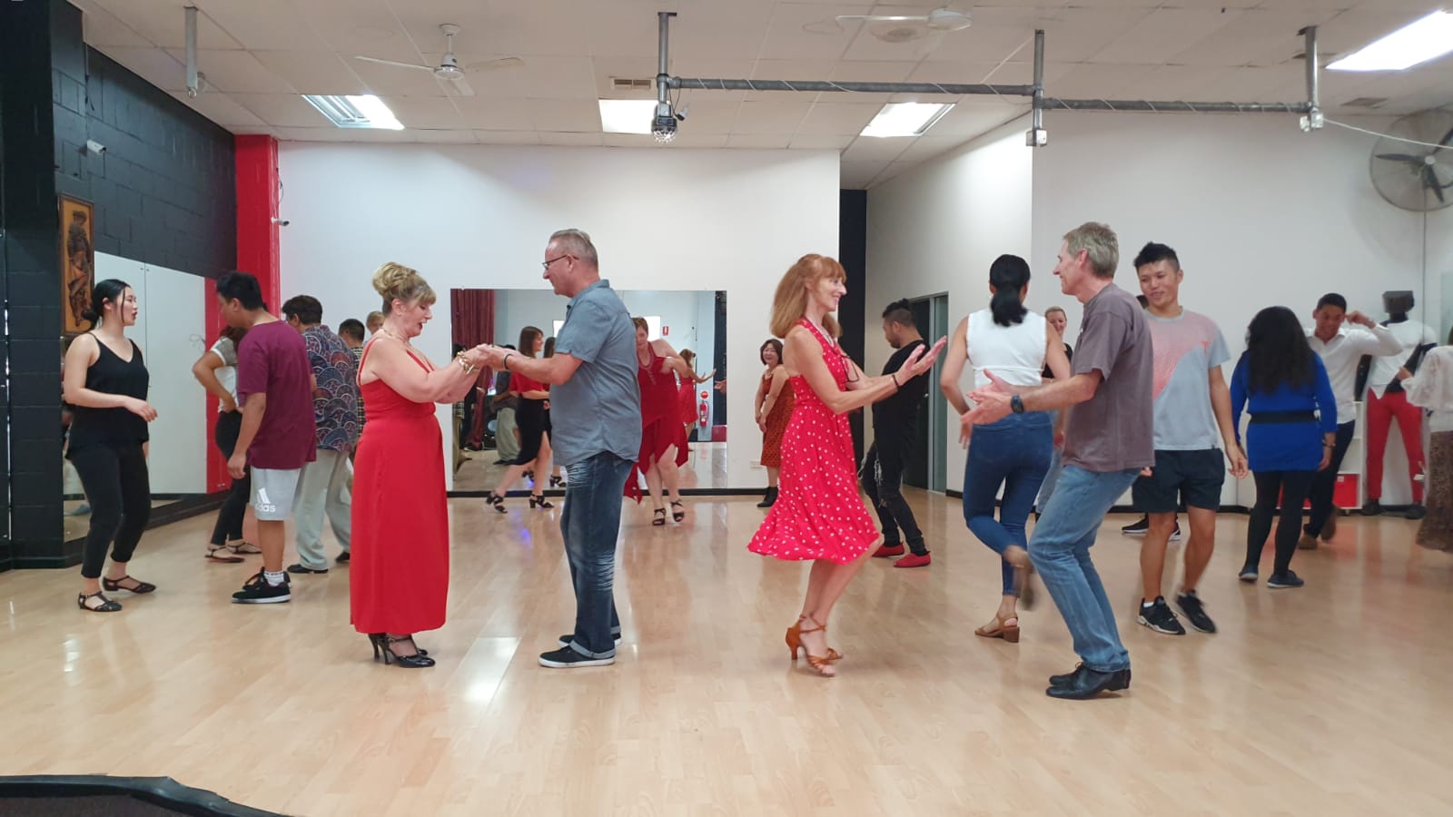 Older generation of couples learning to dance together in a group environment